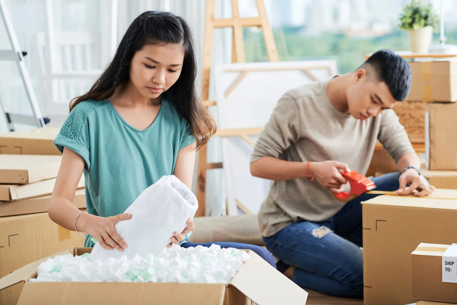 couple enjoys packing items for moving